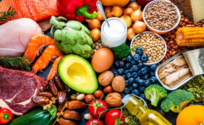Overhead view of a large group of healthy raw food for flexitarian mediterranean diet. The composition includes salmon, chicken breast, canned tuna, cow steak,  fruits, vegetables, nuts, seeds, dairi products, olive oil, eggs and legumes. High resolution 42Mp studio digital capture taken with SONY A7rII and Zeiss Batis 40mm F2.0 CF lens
